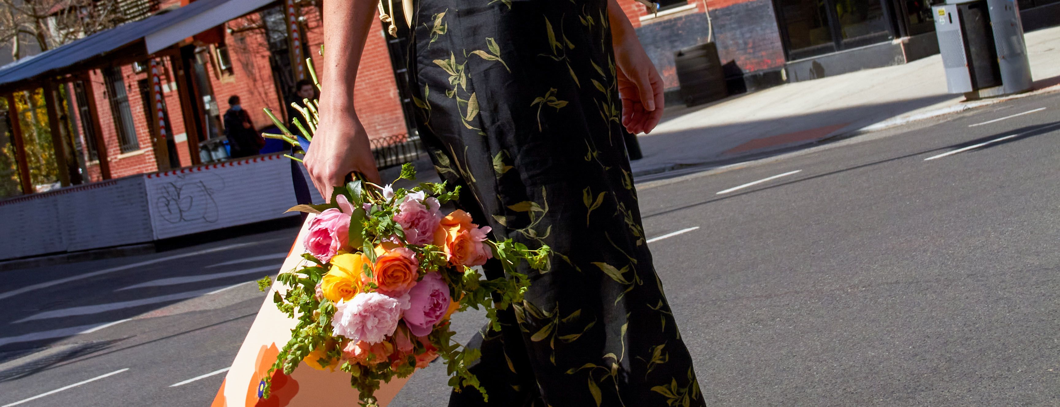 Woman carrying UrbanStems Mothers Day flowers for 2023