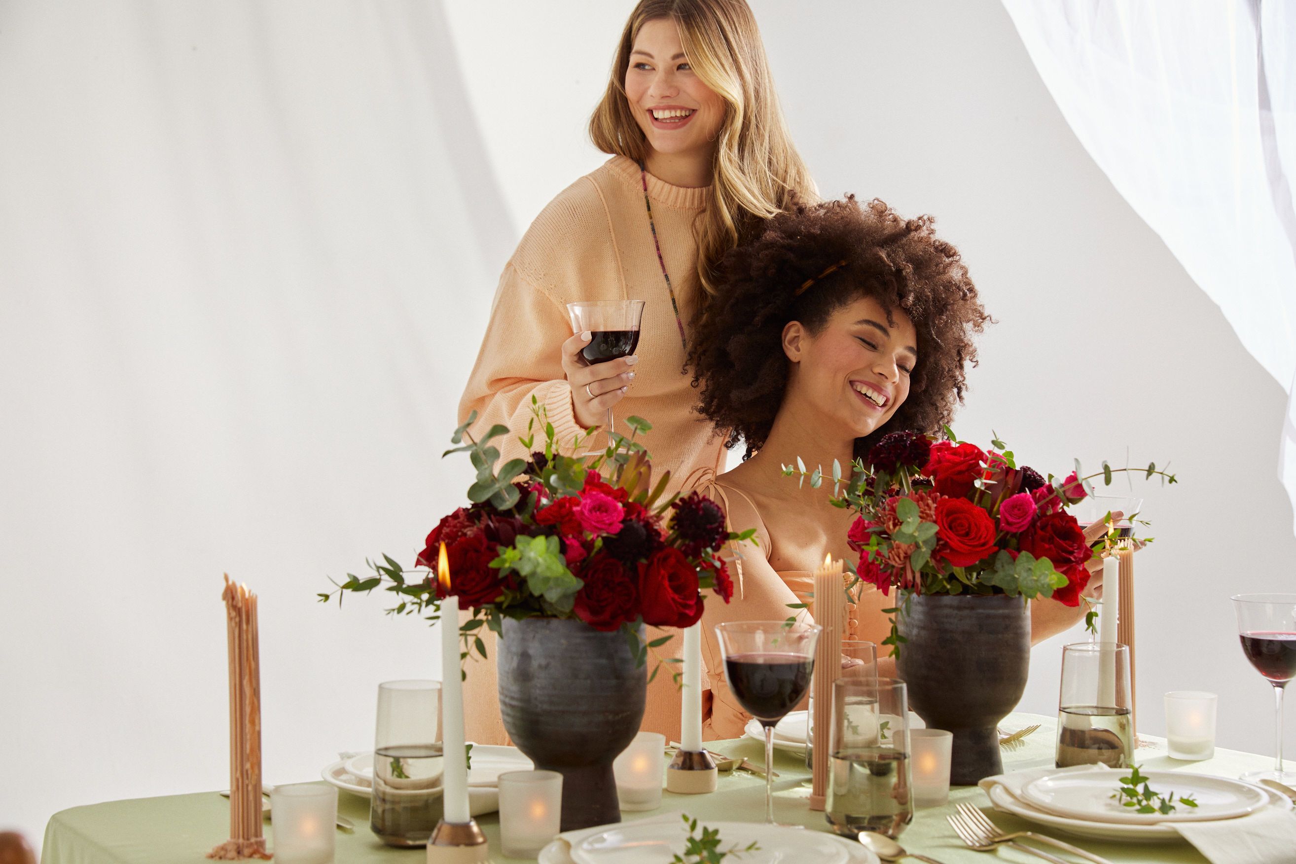 Close up of two women admiring their Valentine's Day flower arrangements.