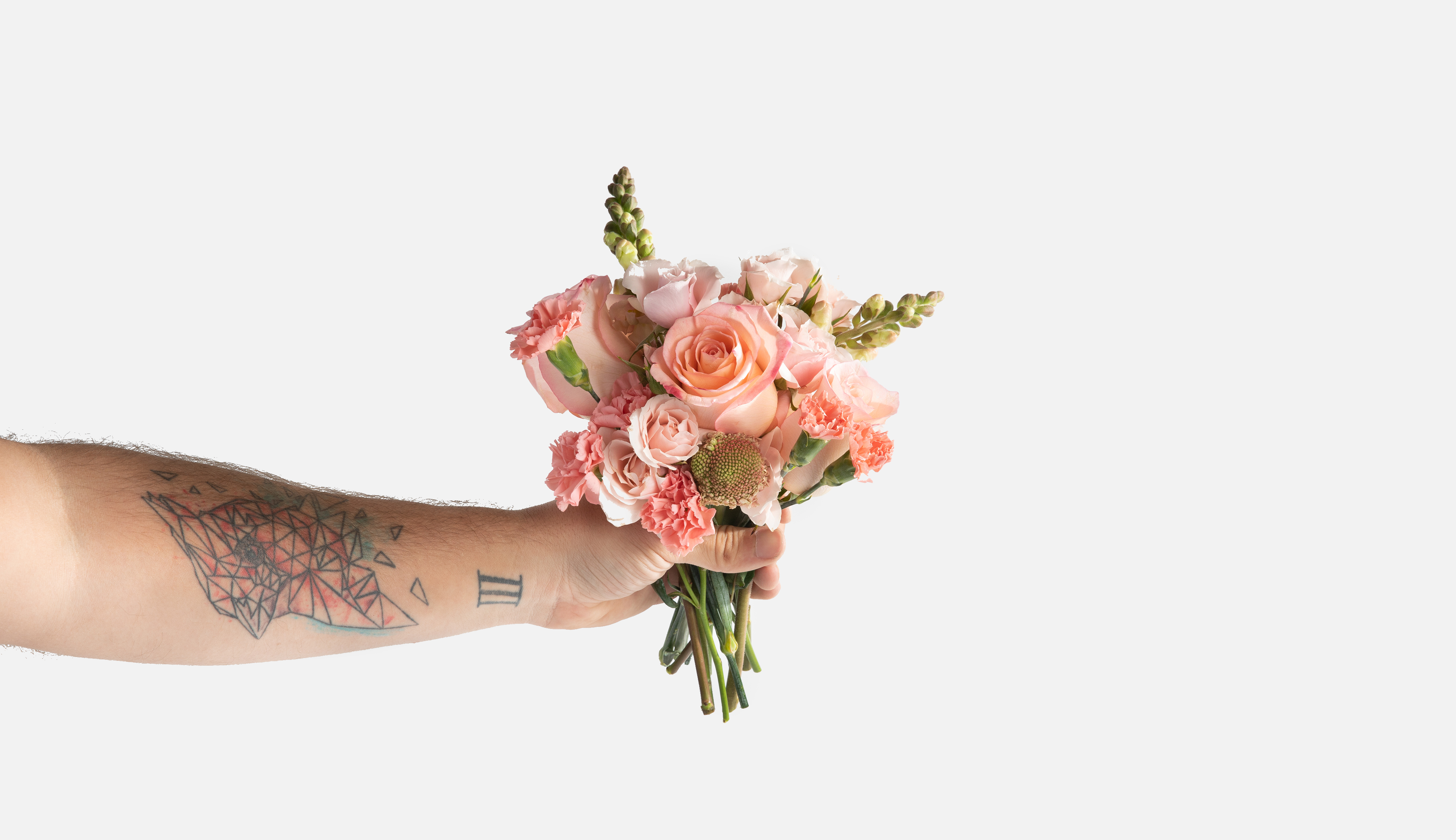 Hand holding a mini bouquet of pink flowers
