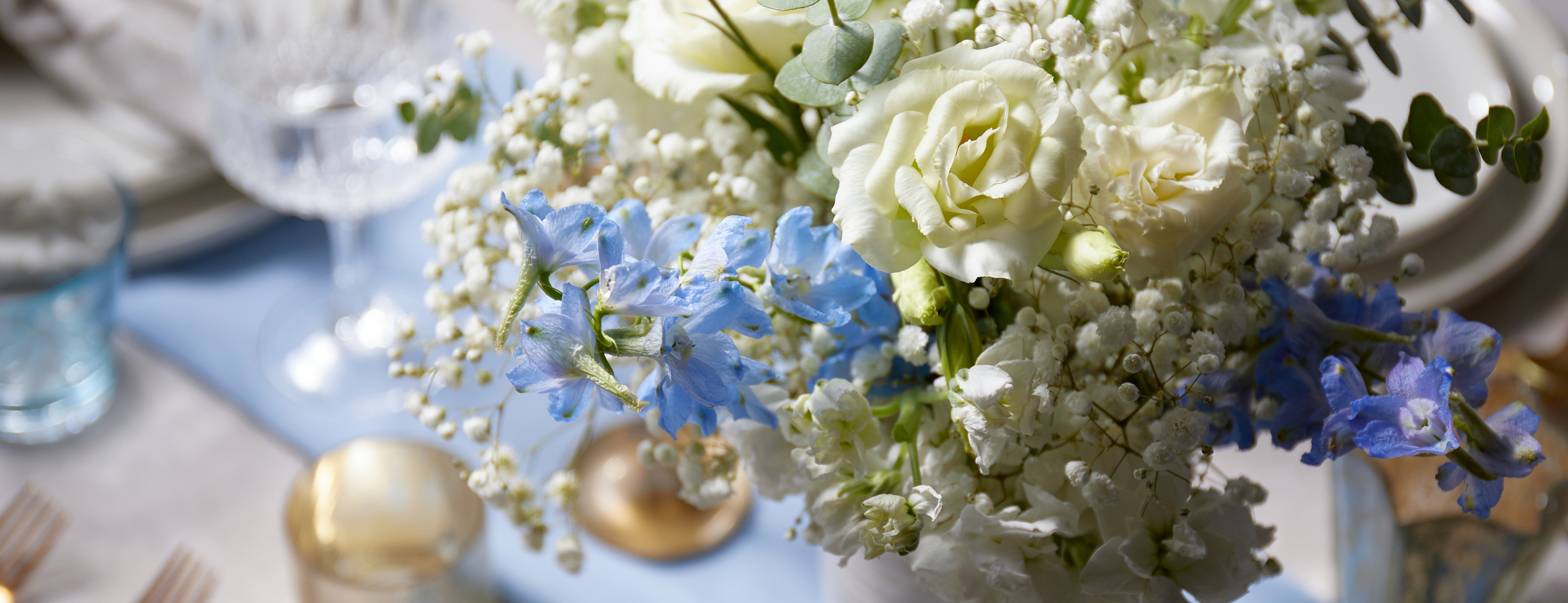 Floral bouquet on set table featuring delphinium flowers