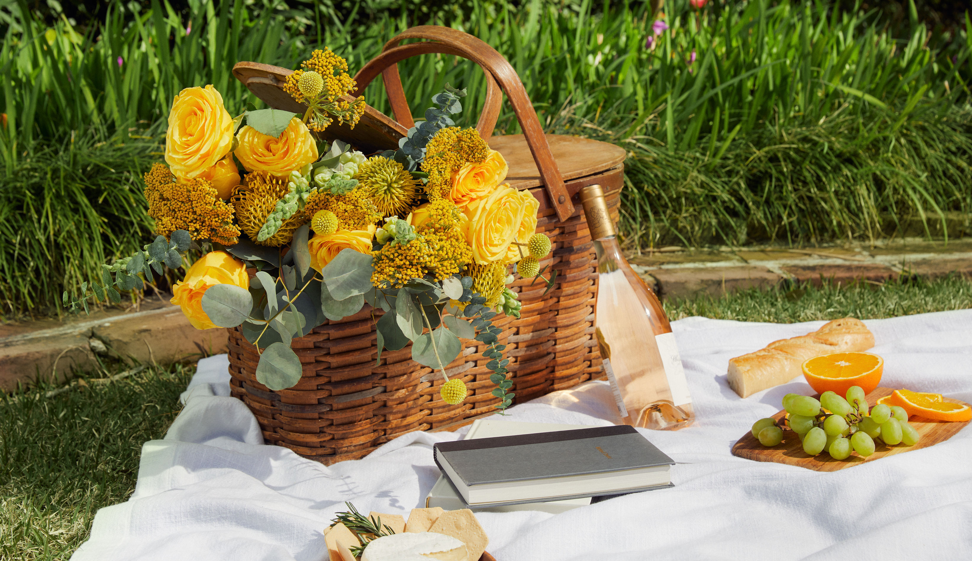 Picnic basket full of flowers outdoors