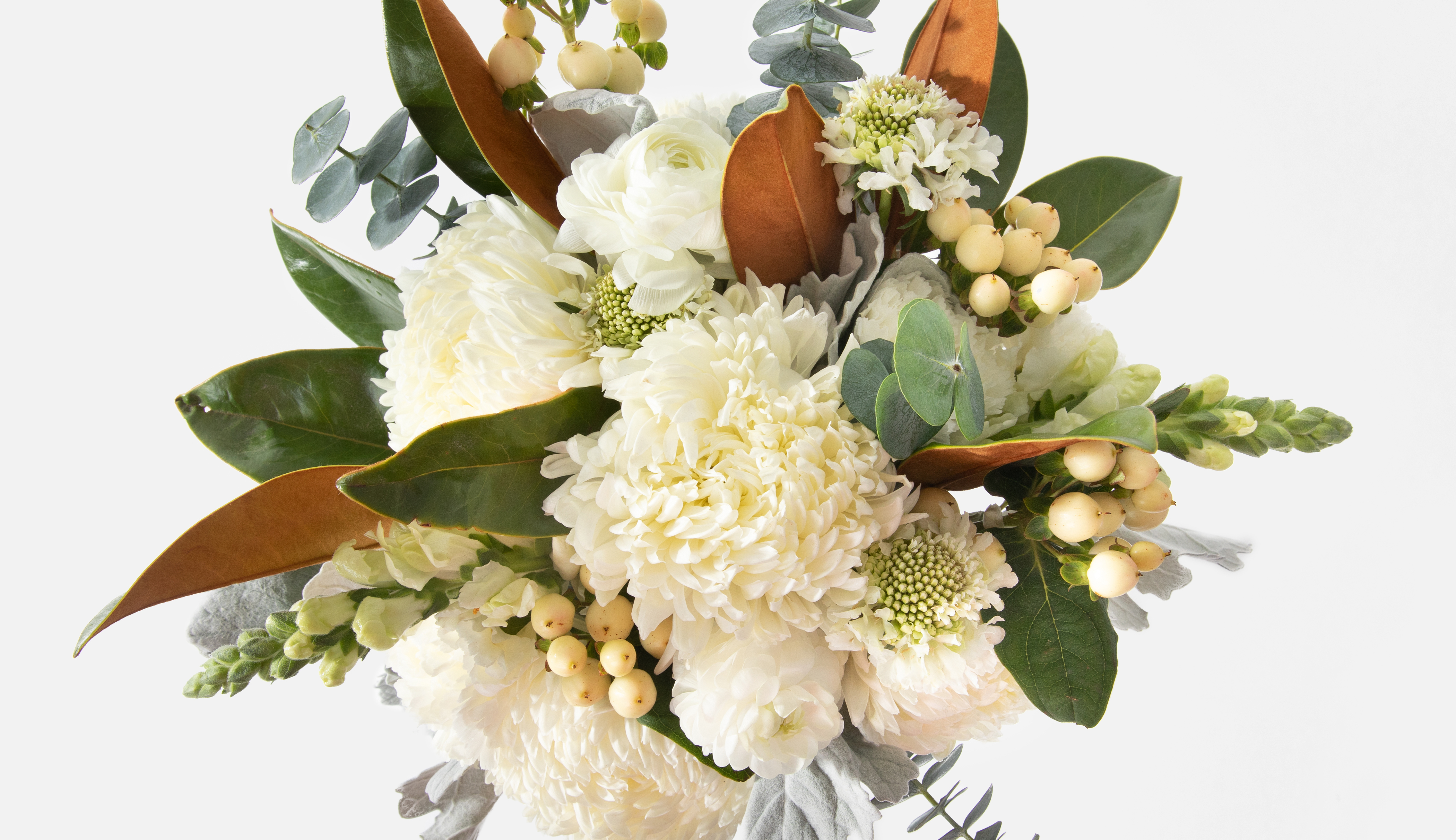 Close up of a floral bouquet containing magnolia leaves