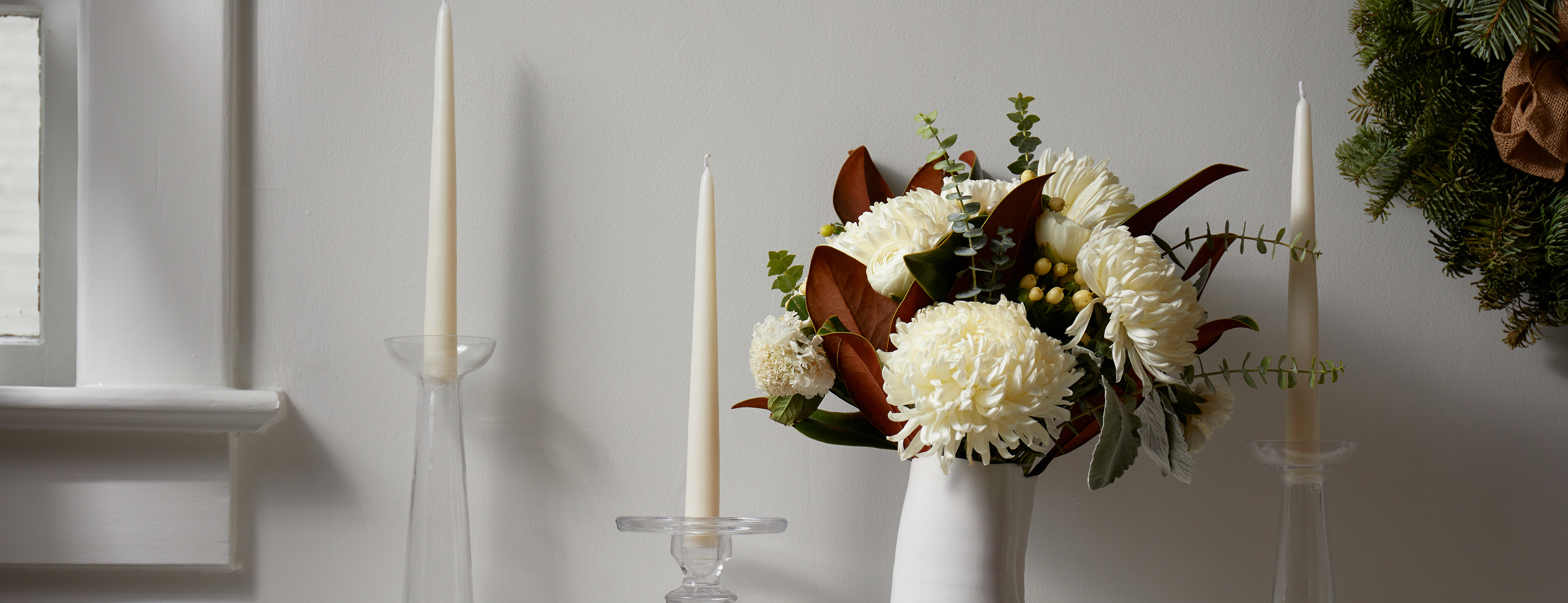 Arrangement with magnolia leaves and tapered candles