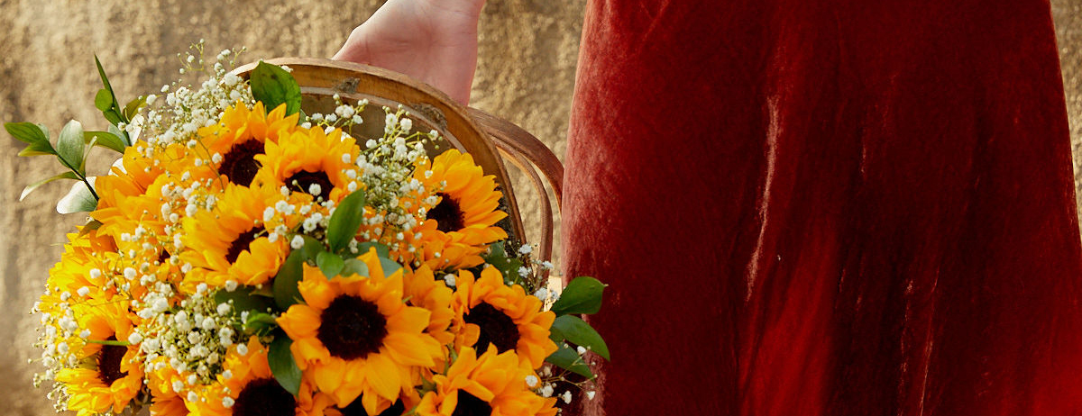 Woman carrying a basket full of sunflowers