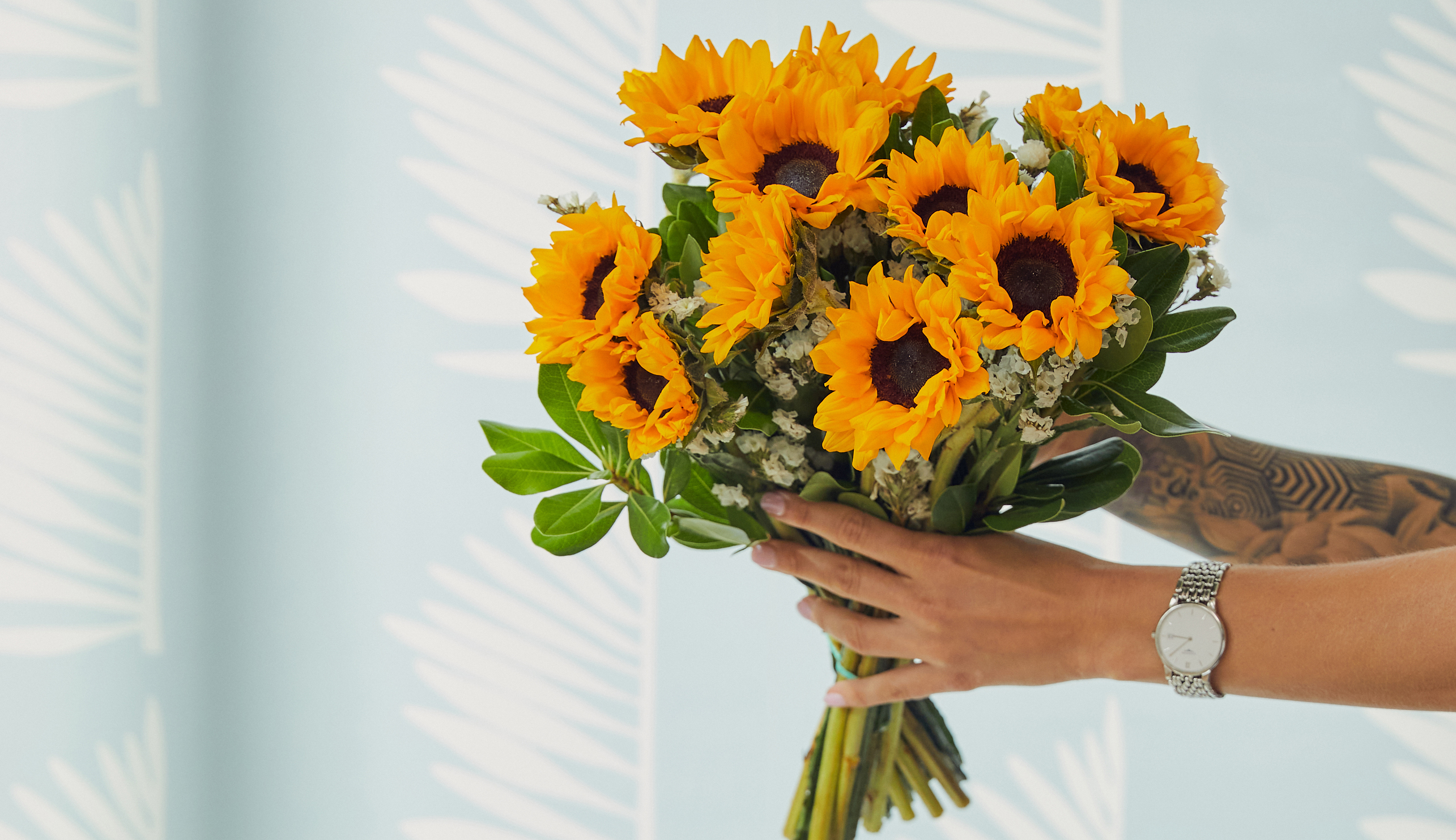 Hands holding sunflower bouquet