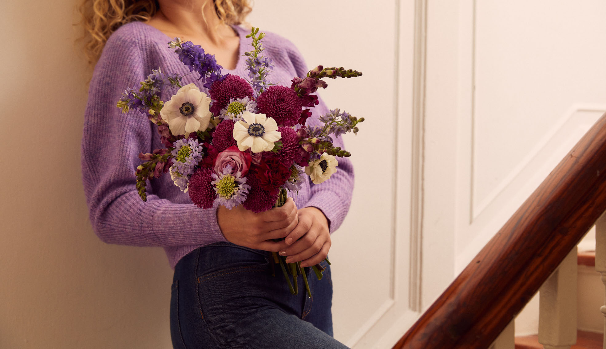 Woman holding a bouquet with purple mums