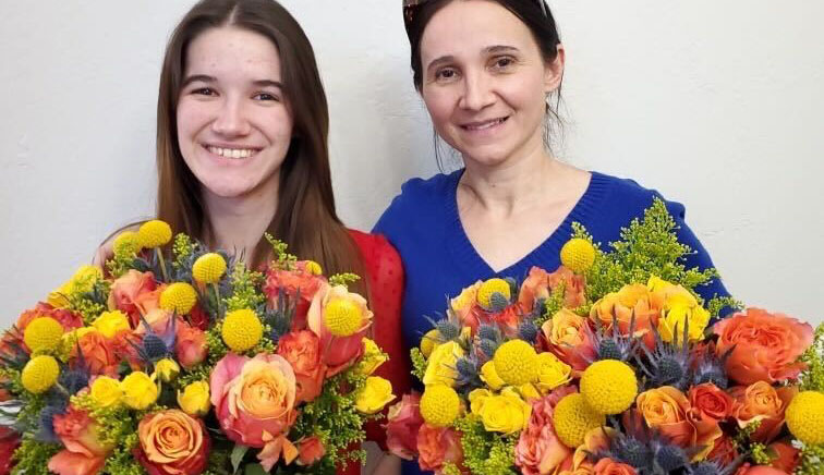 Girl and her mother with orange and yellow Valentine's Day flowers