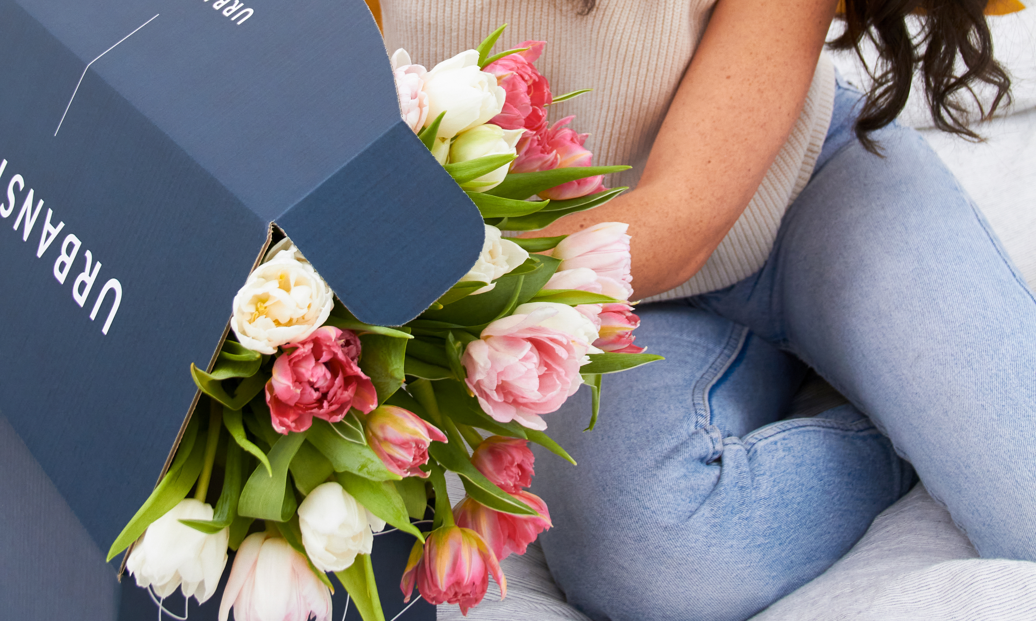 Woman opening a box of tulip flowers for Mother's Day delivery
