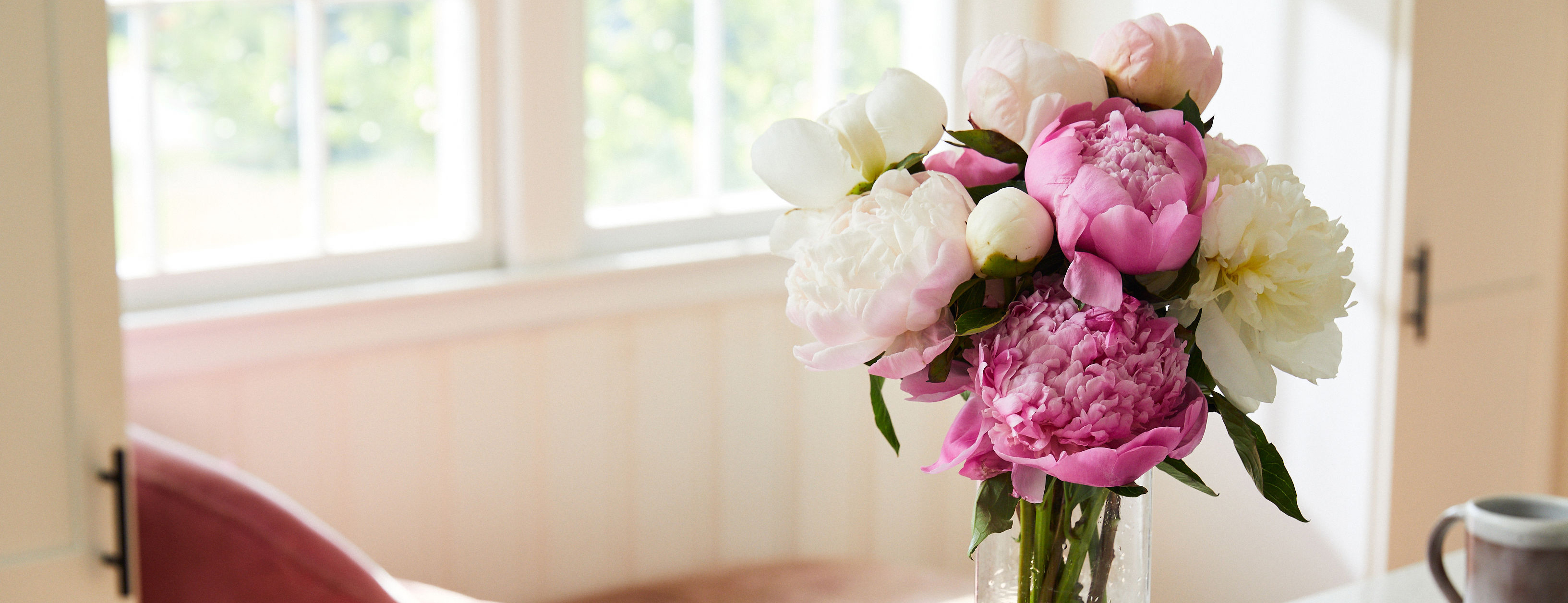 Close up of a pink and white peony bouquet on a table