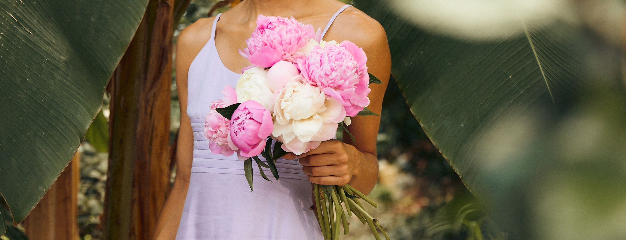 Woman carrying peonies for a summer 2022 wedding