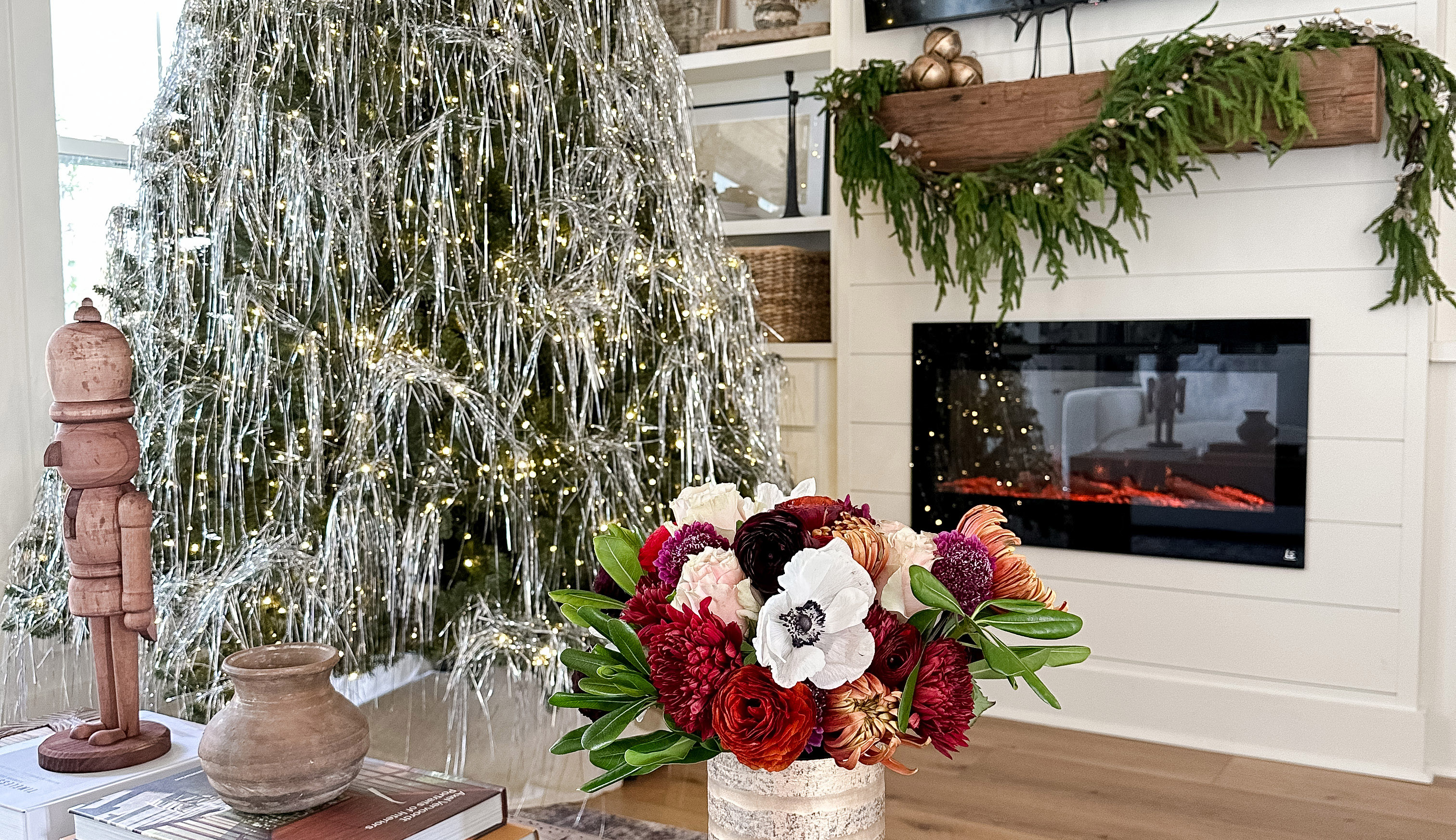 Room decorated for Christmas 2022 with beautiful holiday flowers and a tinsel decorated Christmas tree