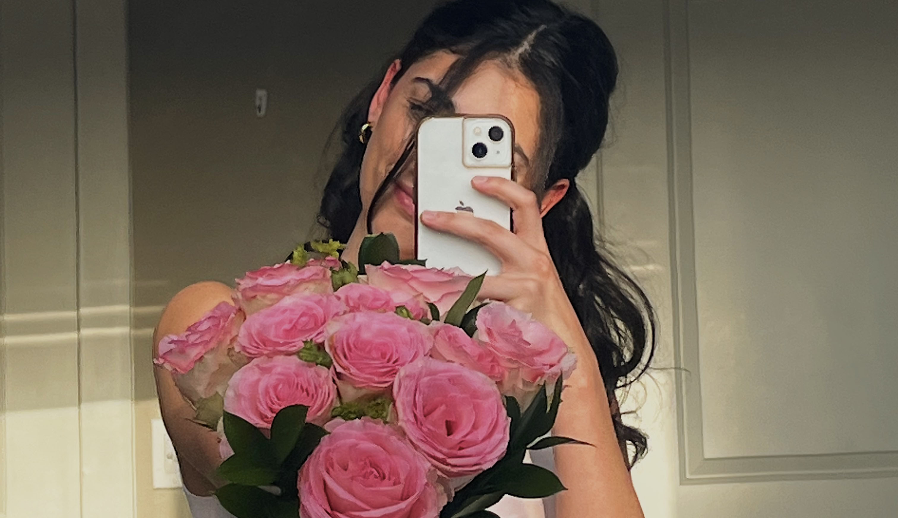Girl posing in the mirror with Valentines Day pink roses for 2023